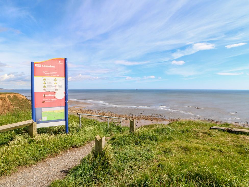 A sign near the ocean with grass at 37 Horizon Park in Hartlepool