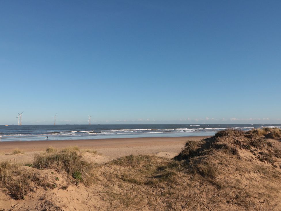 A beach with wind turbines in the ocean at Caravan 132 Redcar