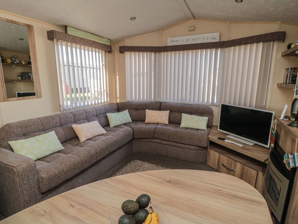A living room with a sofa and a television at Caravan 132 in Redcar