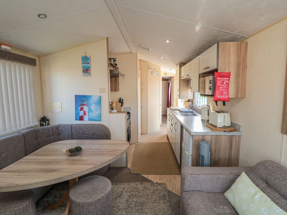 A kitchen with dining area and appliances at Caravan 132 Redcar
