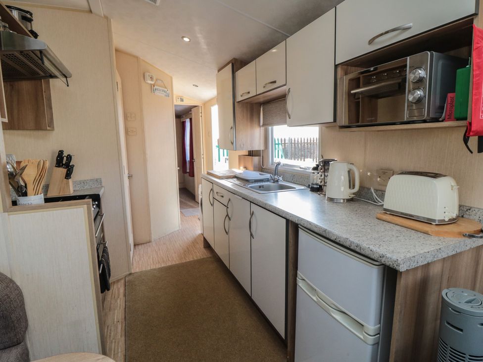 A kitchen with sink and appliances at Caravan 132 in Redcar