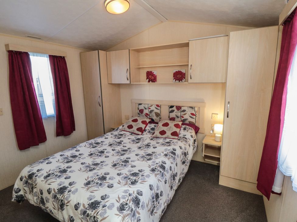 A bedroom with a bed and cupboards at Caravan 132 Redcar