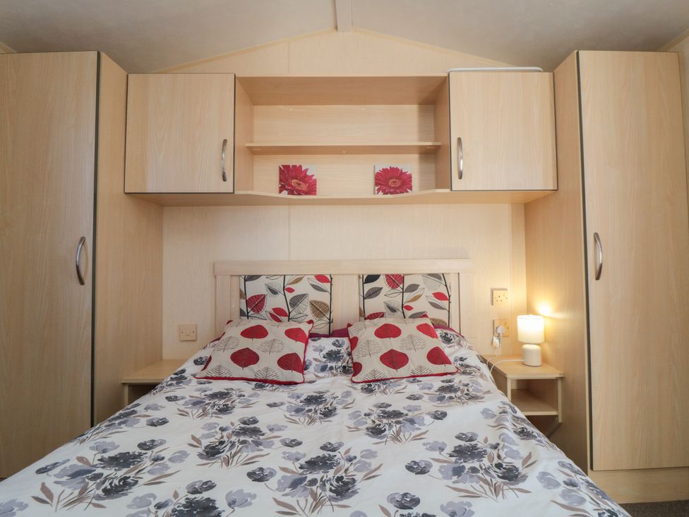 A bedroom with bed and storage units at Caravan 132 Redcar