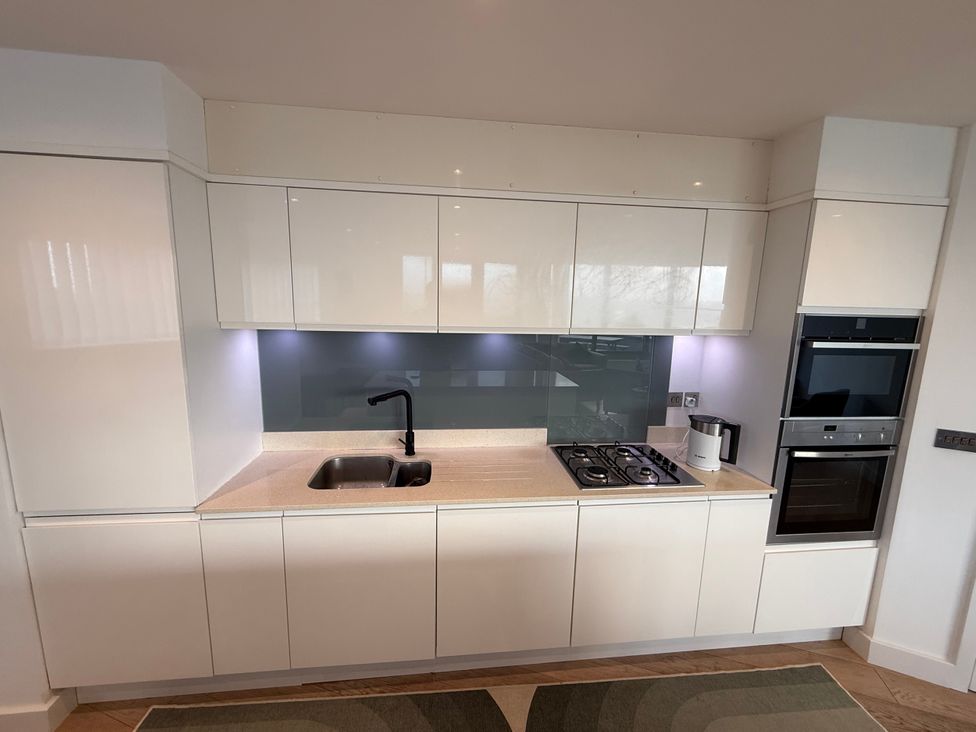 A kitchen with a sink and gas stove at Apartment 29 in Newquay