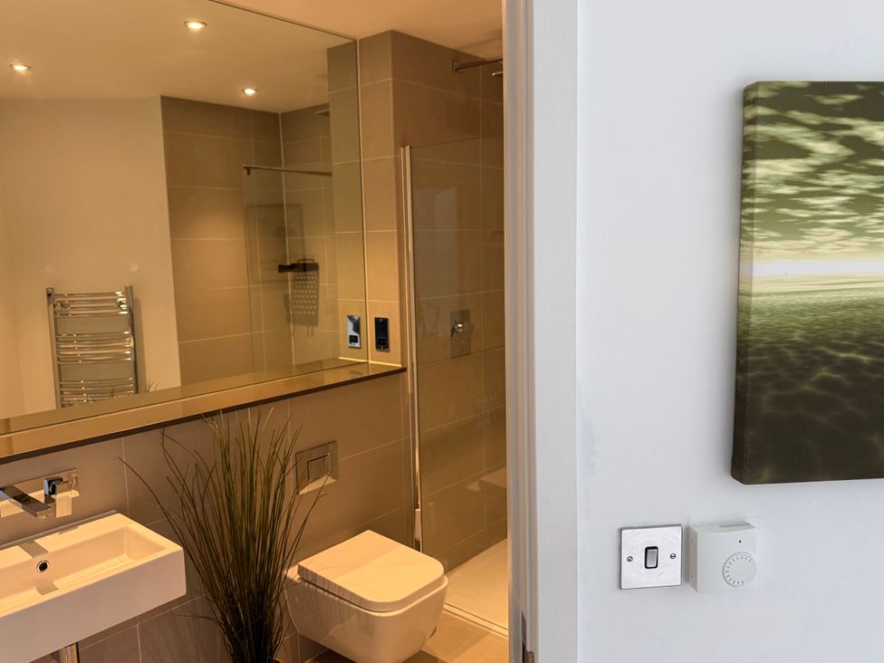 A bathroom with a sink, toilet, and shower at Apartment 29 in Newquay