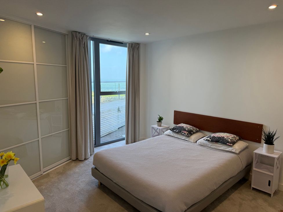 A bedroom with a bed and plants at Apartment 29 in Newquay