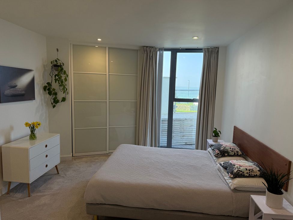 A bedroom with a bed and dresser at Apartment 29 in Newquay