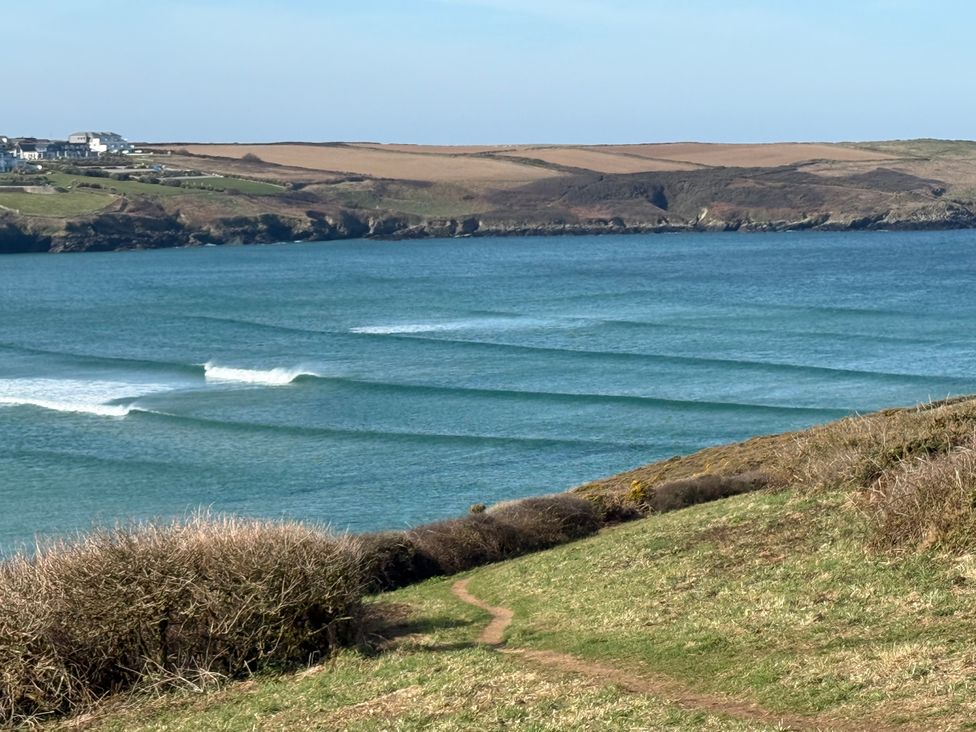 A coastal view with waves and a path leading to the shore at Apartment 29 in Newquay