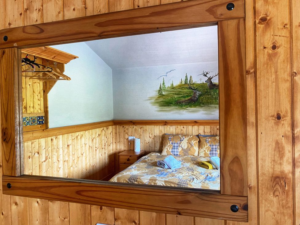 A bedroom with a bed and a reflective mirror at No 6 Enniskillen