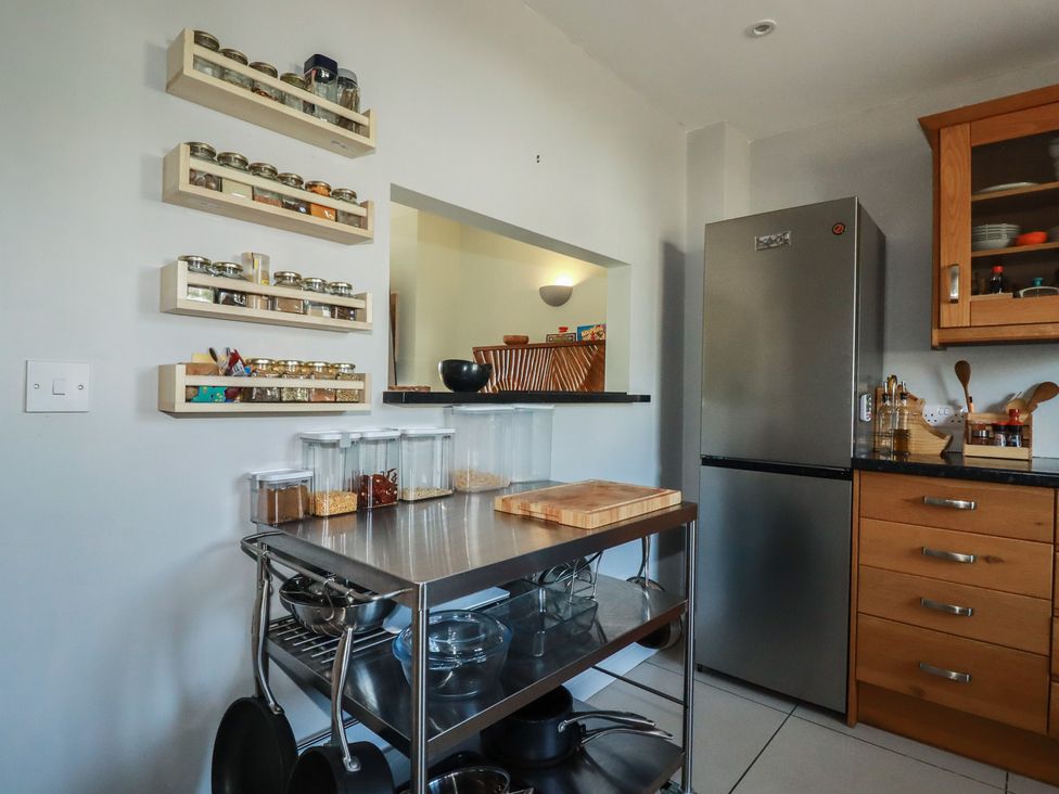 A kitchen with spice jars on a wall and a stainless steel table at Carnweather in Newquay