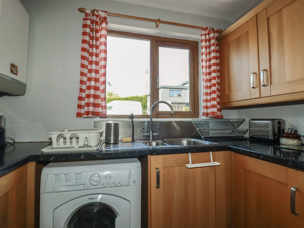 A kitchen with a washing machine and sink at Carnweather in Newquay