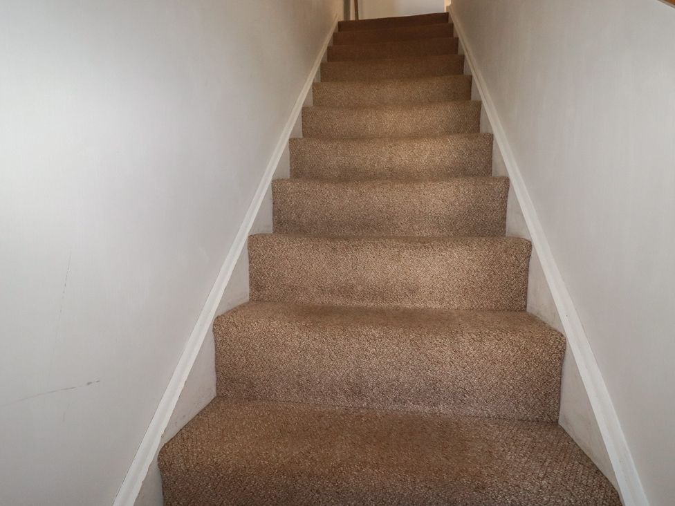 A staircase with carpet in Carnweather, Newquay