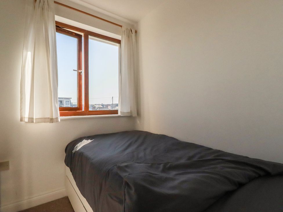 A bedroom with a bed and a window at Carnweather in Newquay