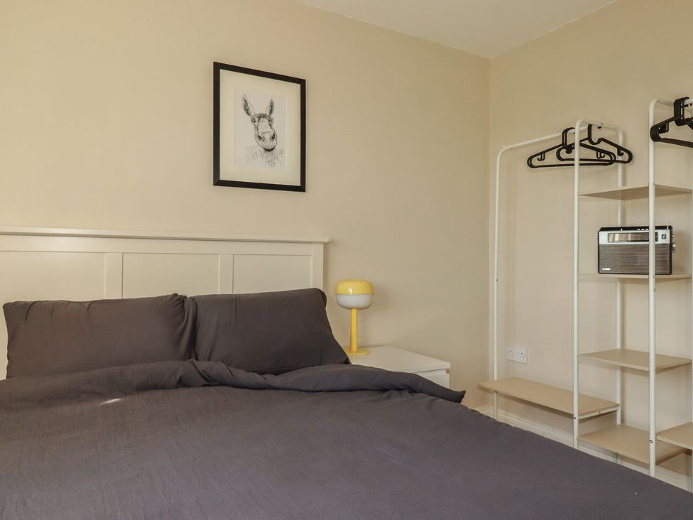 A bedroom with a bed and a lamp at Carnweather in Newquay