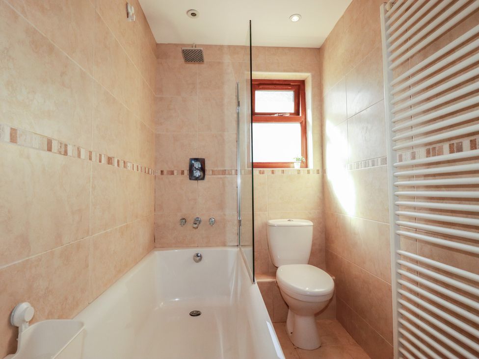 A bathroom with a bathtub and toilet at Carnweather in Newquay