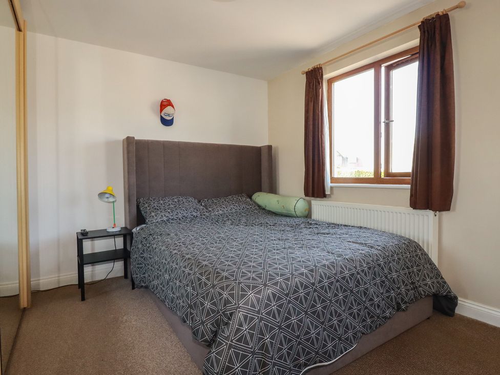 A bedroom with a bed and bedside table at Carnweather in Newquay