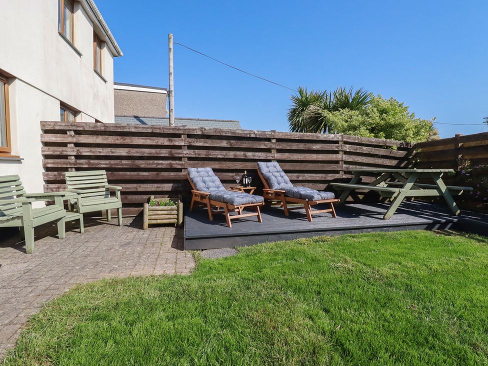 A garden with seating area and lawn at Carnweather in Newquay
