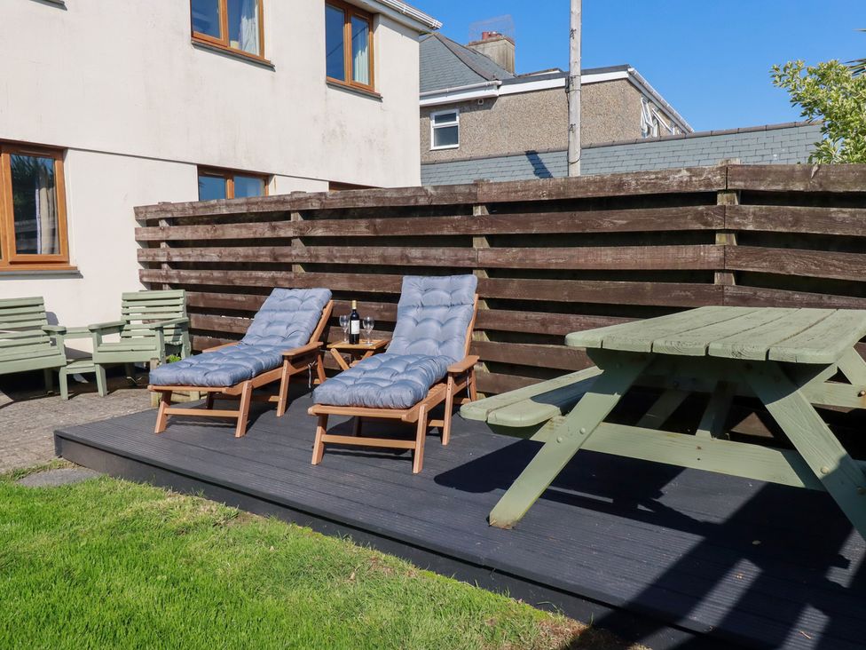 A garden area with lounge chairs and a table at Carnweather Newquay