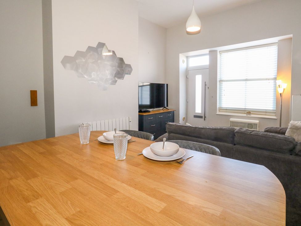 A living room with a TV and dining table at Chandlers Nook in Portland