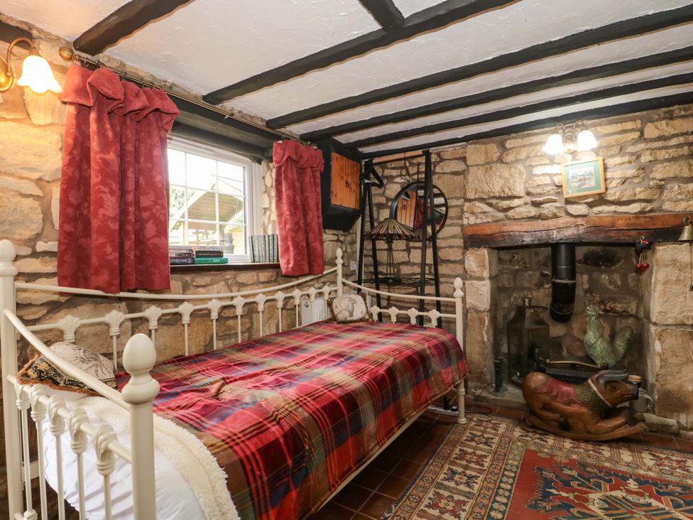 A bedroom with a bed and bookshelves at The Annexe at Cherry Cottage, Upton St Leonards