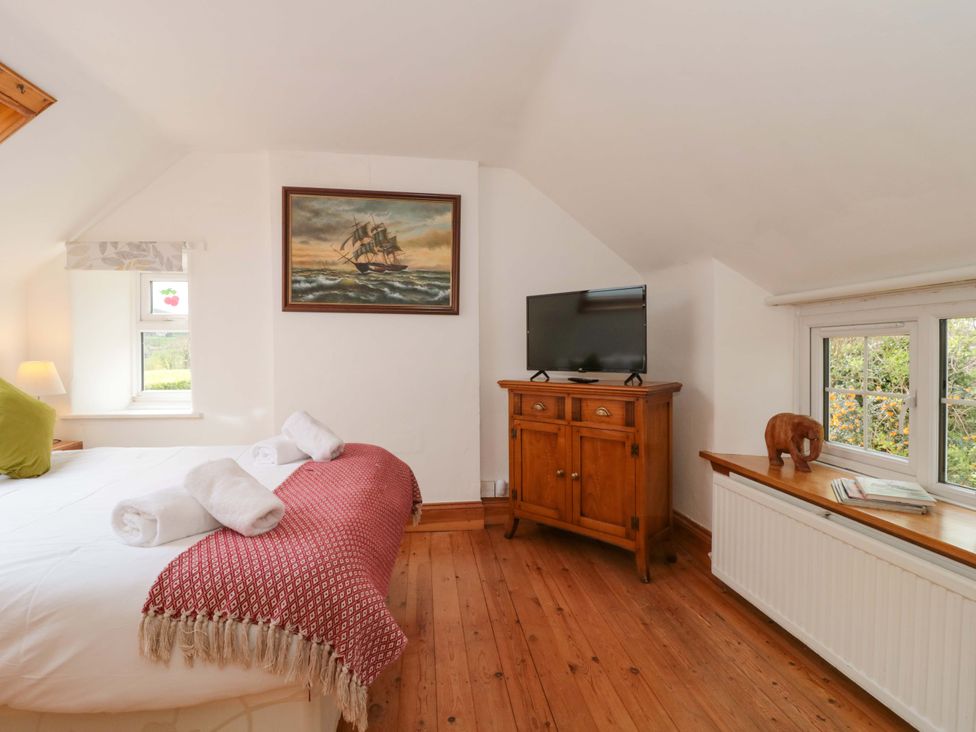 A bedroom with a bed and television in The Annexe at Cherry Cottage Upton St Leonards
