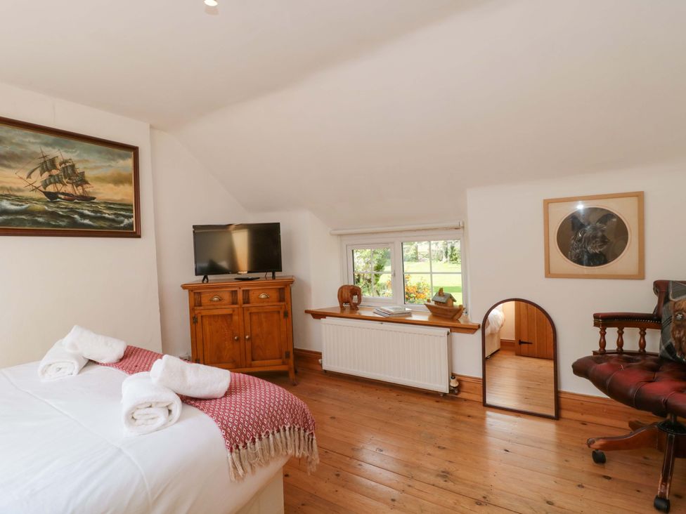 A bedroom with bed, television, and cabinet at The Annexe at Cherry Cottage Upton St Leonards