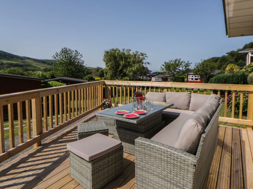 An outdoor seating area with a sofa and table at Chalet 47 Erw Porthor Tywyn
