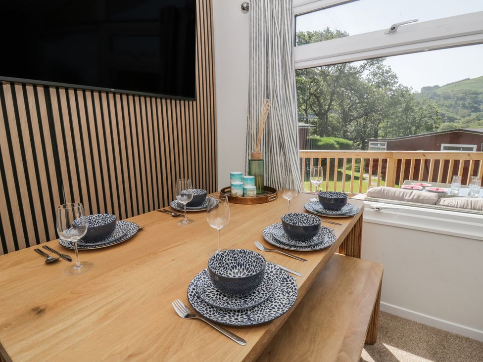 A dining table set with plates and glasses at Chalet 47 Erw Porthor, Tywyn