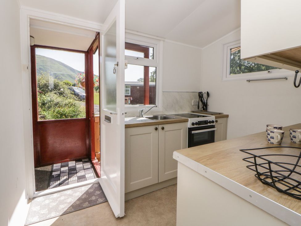 A kitchen with sink and stove at Chalet 47 Erw Porthor Tywyn