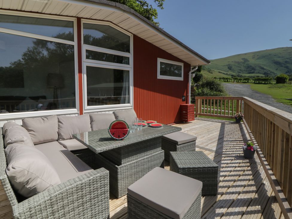 An outdoor seating area with a sofa and table at Chalet 47 Erw Porthor Tywyn