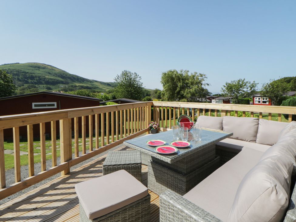 An outdoor seating area with a table and couch at Chalet 47 Erw Porthor Tywyn