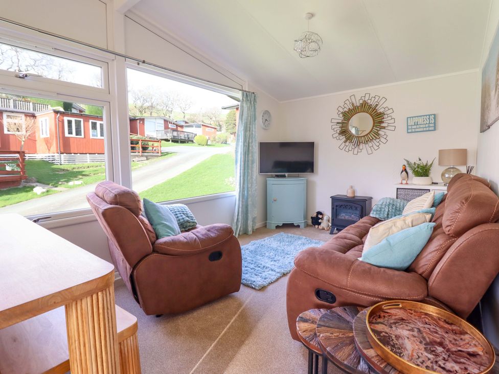 A living room with a sofa and television at Chalet 23 Erw Porthor Tywyn