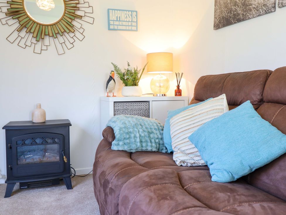 A living room with a couch and decorative items at Chalet 23 Erw Porthor Tywyn