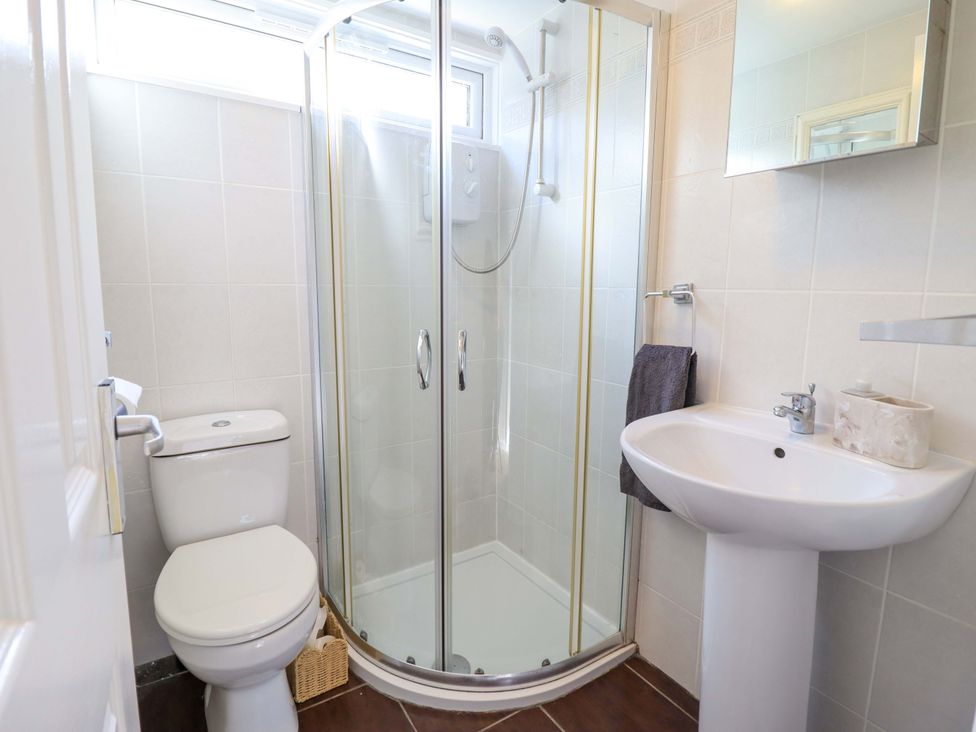 A bathroom with a shower, toilet, and sink at Chalet 23 Erw Porthor, Tywyn