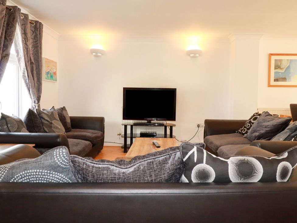 A living room with a television and sofas at 62 Golf Lodges in Atlantic Reach near Fraddon