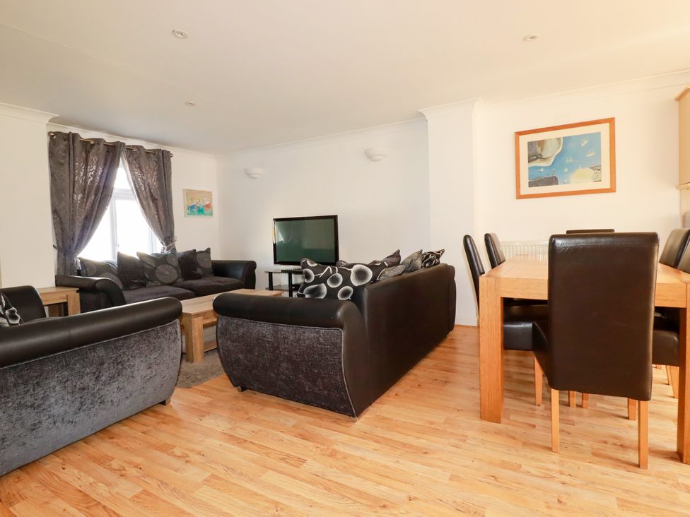 A living room with sofa and dining area at 62 Golf Lodges Atlantic Reach near Fraddon