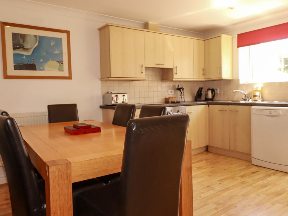 A kitchen with a dining table and chairs at 62 Golf Lodges Atlantic Reach near Fraddon