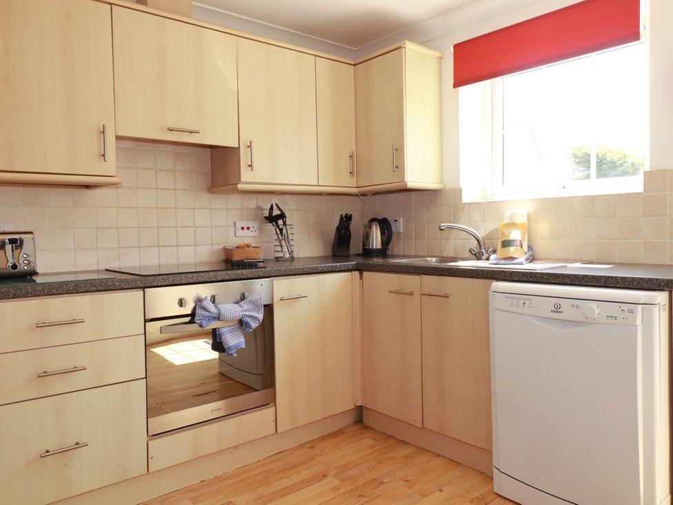 A kitchen with cabinets, sink, dishwasher, and oven at 62 Golf Lodges, Atlantic Reach near Fraddon