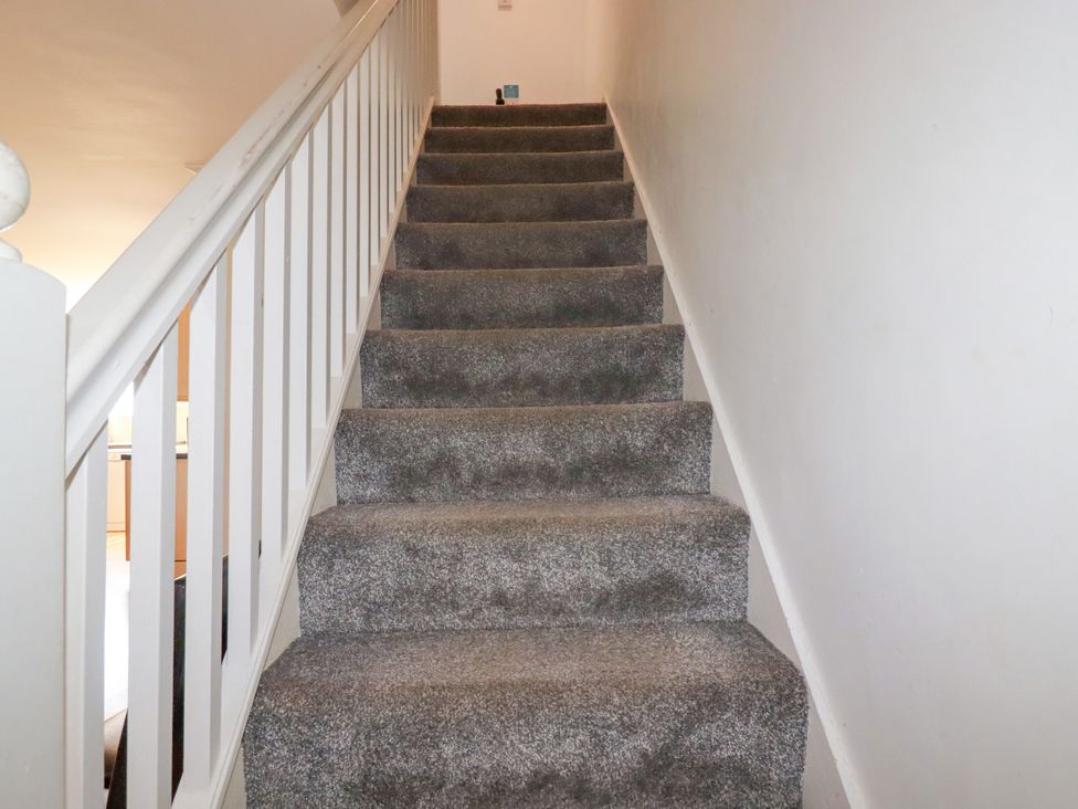 A staircase with carpet and a handrail at 62 Golf Lodges Atlantic Reach near Fraddon