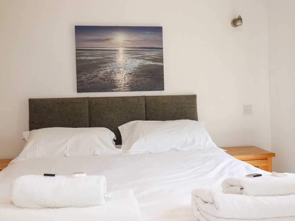 A bedroom with a double bed and wall art at 62 Golf Lodges Atlantic Reach near Fraddon