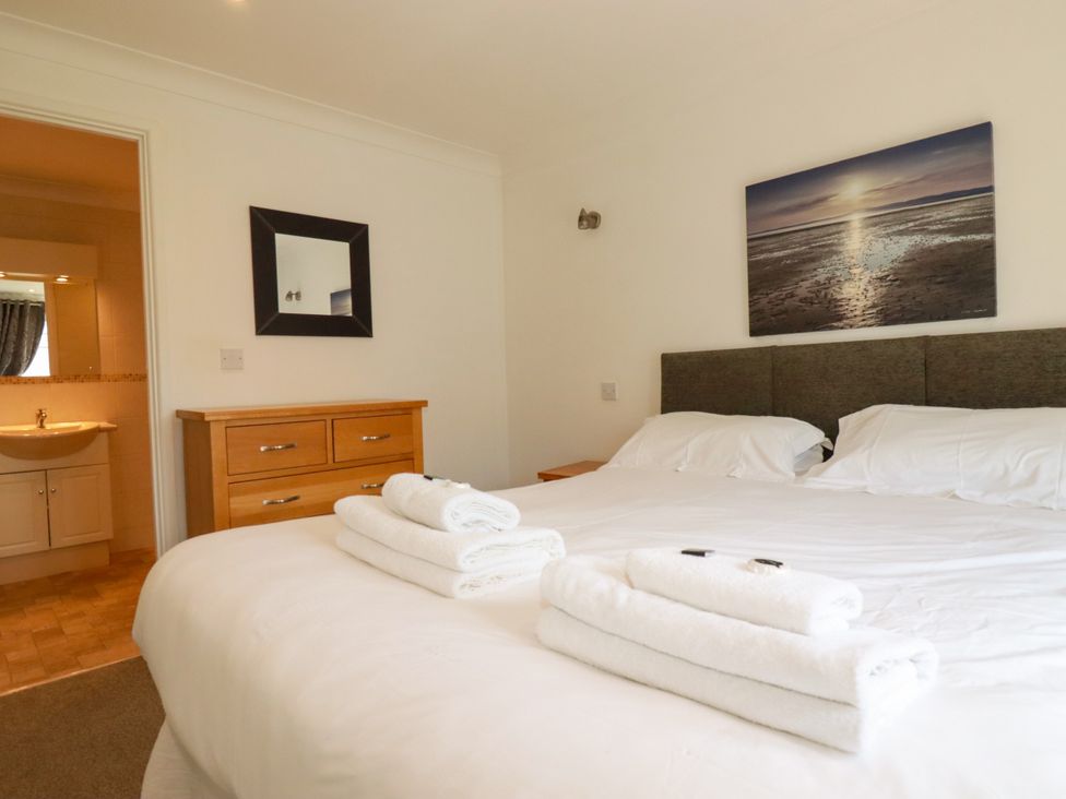 A bedroom with a large bed and towels on top at 62 Golf Lodges Atlantic Reach near Fraddon