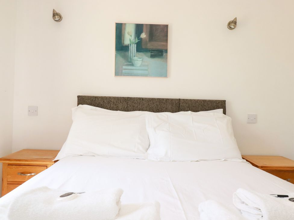 A bedroom with a bed and nightstand at 62 Golf Lodges Atlantic Reach near Fraddon
