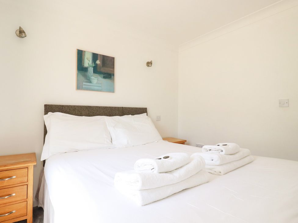 A bedroom with a bed and towels on a nightstand at 62 Golf Lodges Atlantic Reach near Fraddon