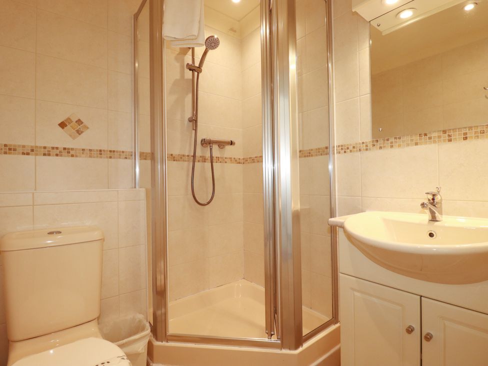 A bathroom with a shower, sink, and toilet at 62 Golf Lodges Atlantic Reach near Fraddon