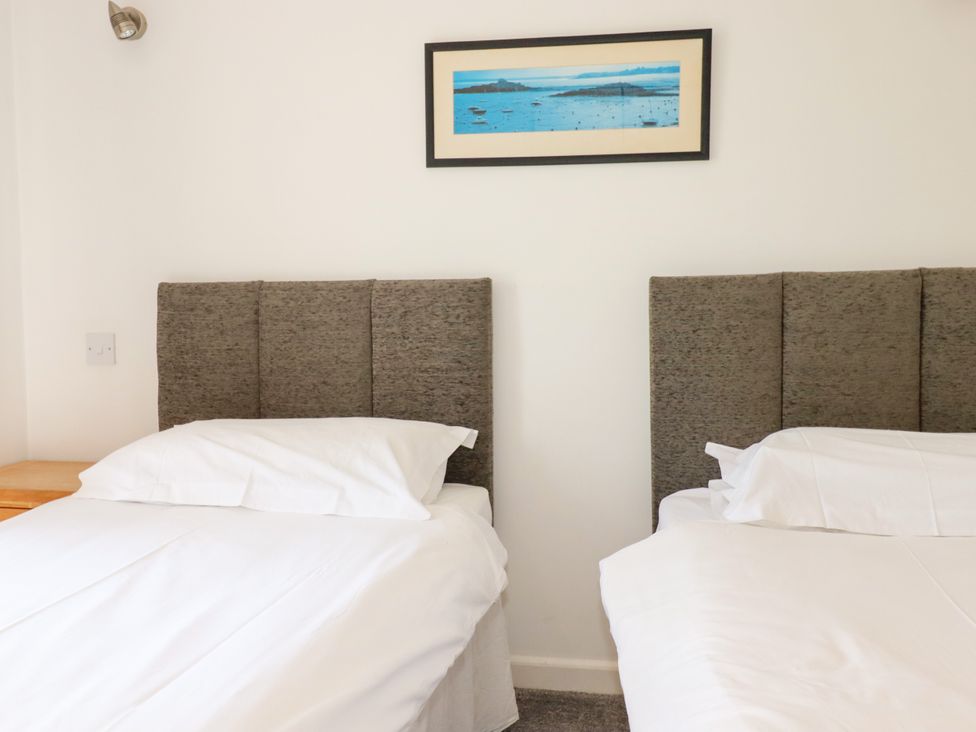 A bedroom with two single beds and a painting at 62 Golf Lodges, Atlantic Reach near Fraddon