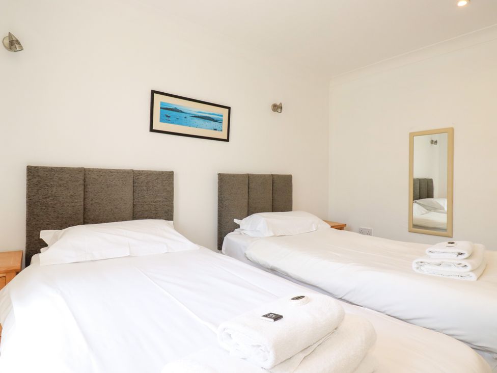 A bedroom with two single beds and a mirror at 62 Golf Lodges Atlantic Reach near Fraddon