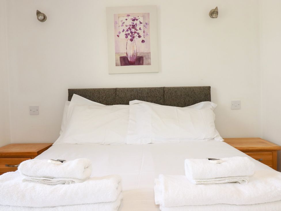 A bedroom with a bed and towels at 62 Golf Lodges, Atlantic Reach near Fraddon