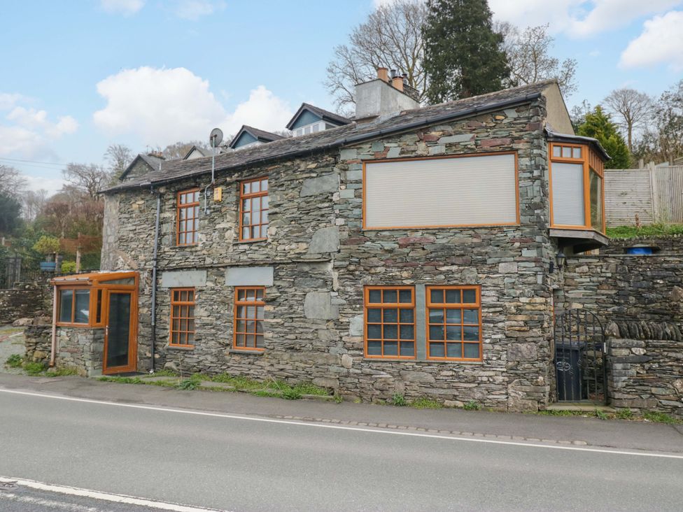 A stone building with windows and a door at Wilders Wood in Windermere