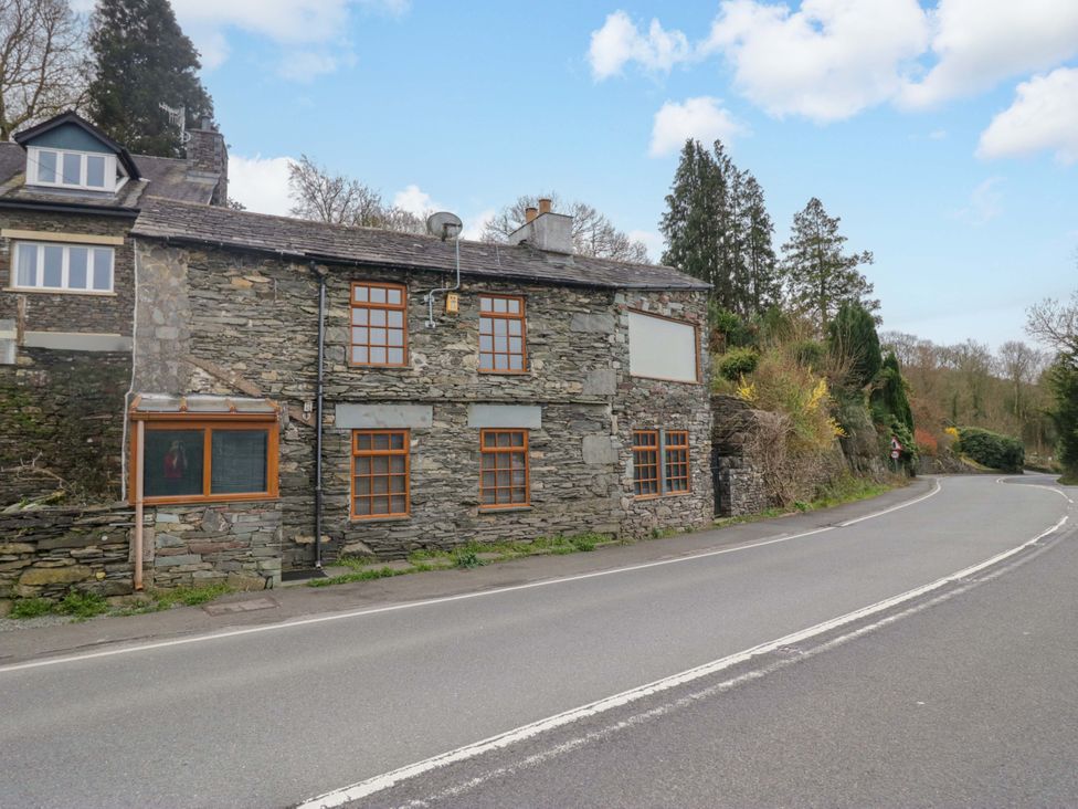 A stone building next to a road at Wilders Wood in Windermere