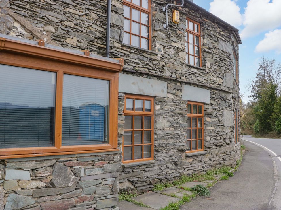 A stone building with windows and a pathway at Wilders Wood in Windermere